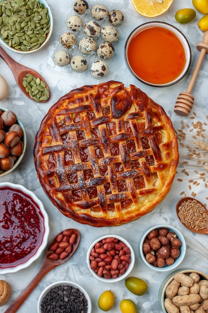 Top view yummy fruity pie with nuts and eggs on light bake biscuit pie dessert color tea cake cookie bun