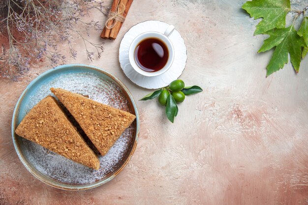 Top view yummy honey cake with tea on light