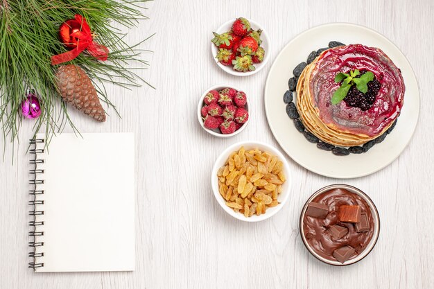 Foto gratuita vista dall'alto gustose frittelle di gelatina con uvetta e frutta su bianco