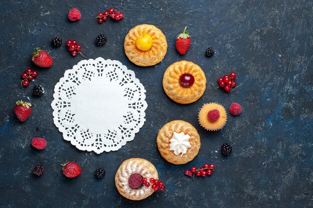 Top view yummy little cakes with berries fruits on the dark background berry fruit cake biscuit bake