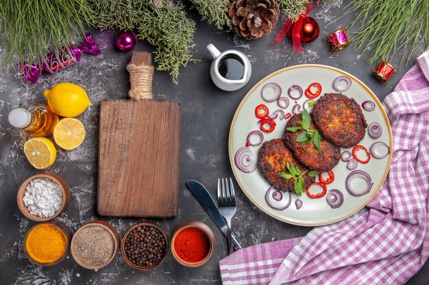 Вид сверху вкусные мясные котлеты с приправами на светло-сером фоне фото еды блюдо