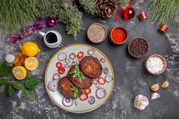 Top view yummy meat cutlets with seasonings on light-grey desk meal photo dish