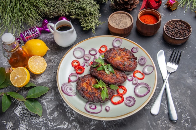 Top view yummy meat cutlets with seasonings on light-grey floor meal photo dish