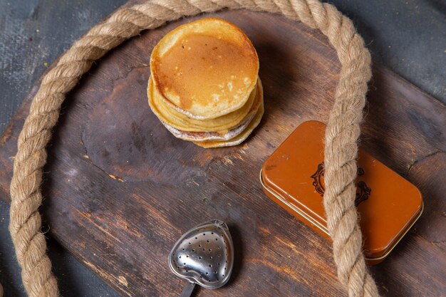 Вид сверху вкусные кексы, запеченные и вкусные с веревками на деревянном столе и сером фоне еда еда сладкий завтрак