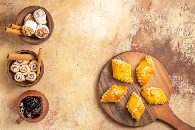 Top view yummy nut cakes with confitures on wooden background