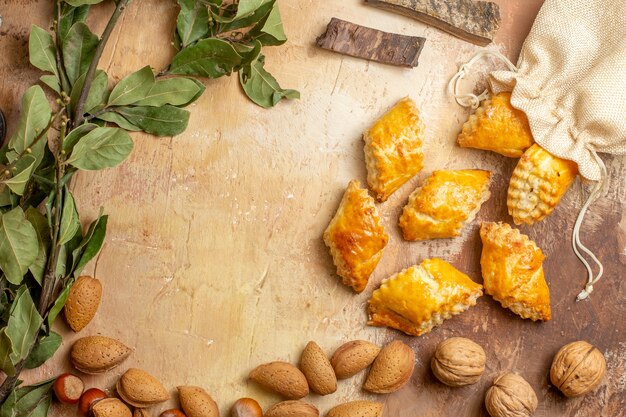 Top view of yummy nut pastries with nuts on a brown background