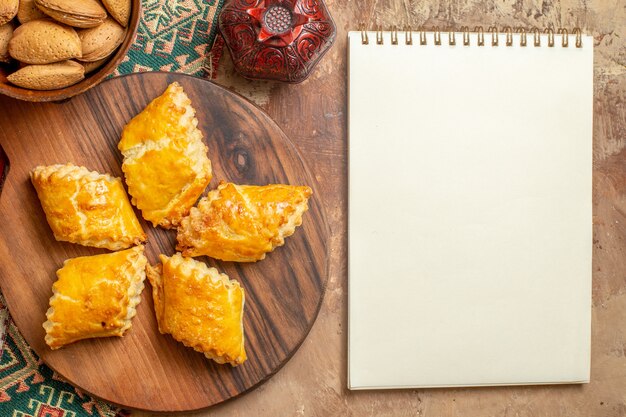 Top view of yummy nut pastries with nuts on the brown background