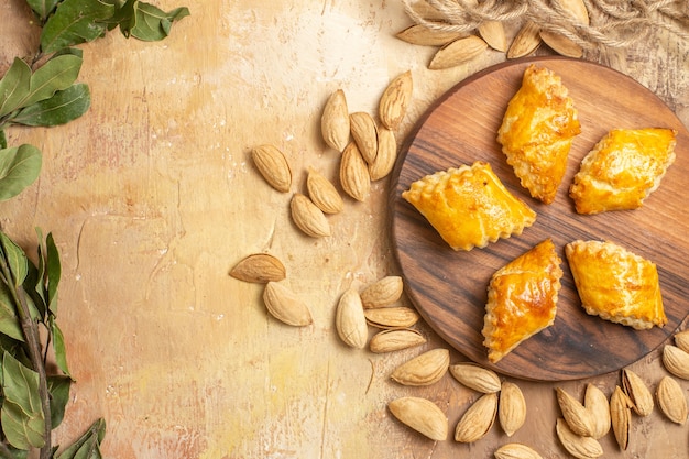 Top view yummy nut pastries with nuts on wooden desk