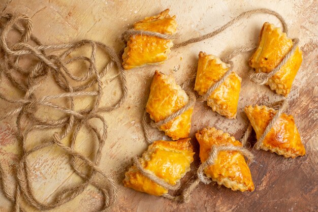 Top view of yummy nut pastries with ropes on brown background