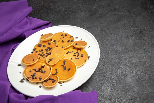 Top view yummy pancakes with choco chips on dark desk