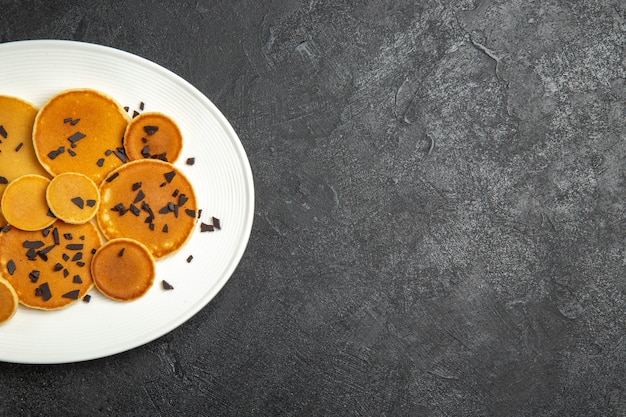 Top view yummy pancakes with choco chips on dark desk