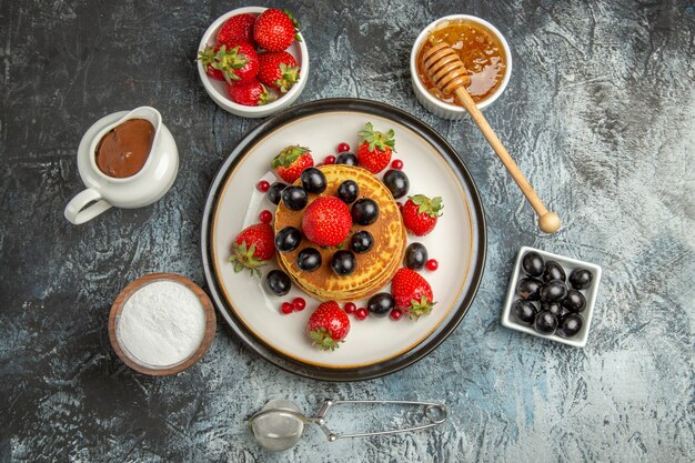 Top view yummy pancakes with fresh fruits on light