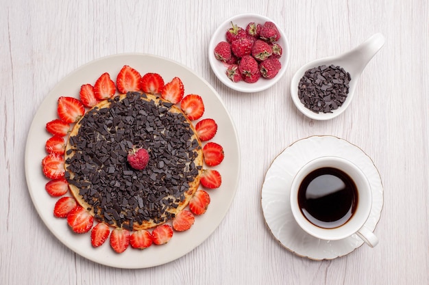 白いテーブルの上に新鮮なイチゴとチョコレートチップとおいしいパンケーキの上面図