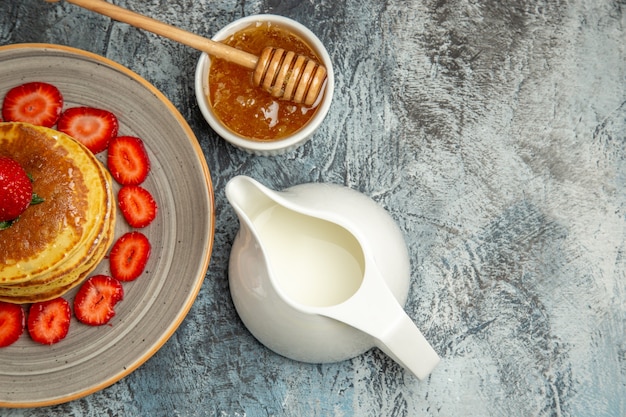 Free photo top view yummy pancakes with fruits and honey on light