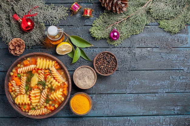 Foto gratuita vista dall'alto gustosa zuppa di pasta da pasta italiana a spirale con verdure sulla scrivania blu scuro cucina zuppa di pasta piatto per cena colore