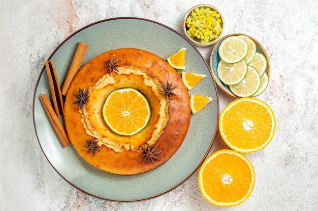 Вид сверху вкусный пирог вкусный десерт к чаю с лимоном и апельсином на белом фоне фруктовый торт пирог чай бисквит сладкий десерт
