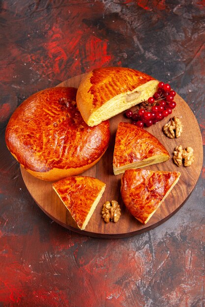 Top view of yummy pies sliced with red berries