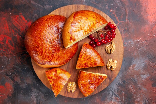 Top view of yummy pies sliced with red berries