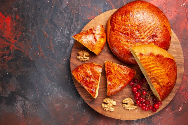 Top view of yummy pies sliced with red berries