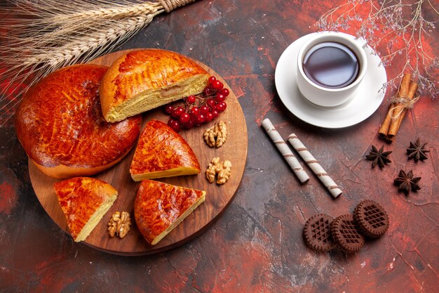 Top view of yummy pies sliced with red berries