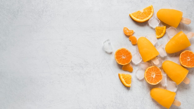 Top view of yummy popsicles with orange and copy space