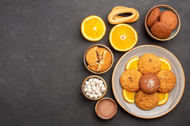 Free photo top view yummy sand cookies with sliced oranges on dark background fruit citrus biscuit sweet cake cookie