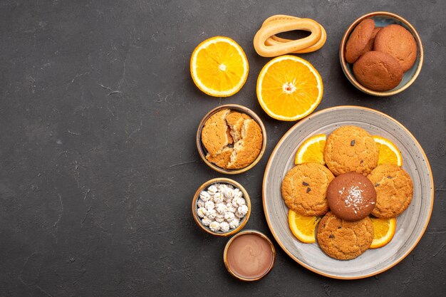 Top view yummy sand cookies with sliced oranges on dark background fruit citrus biscuit sweet cake cookie