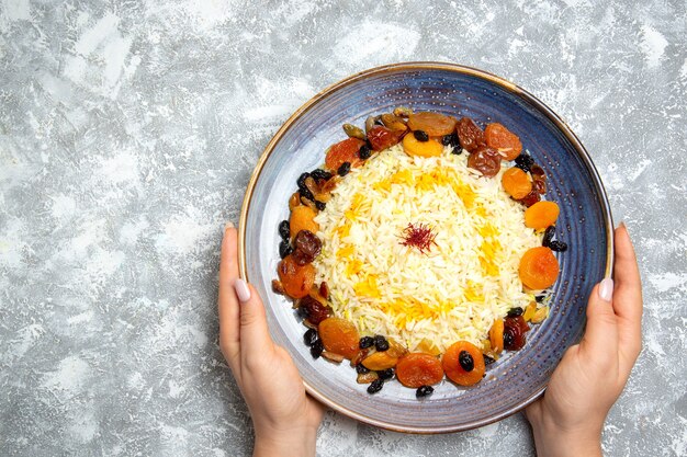 상위 뷰 맛있는 샤크 플 로브 흰색 책상에 접시 안에 건포도와 쌀 요리를 요리