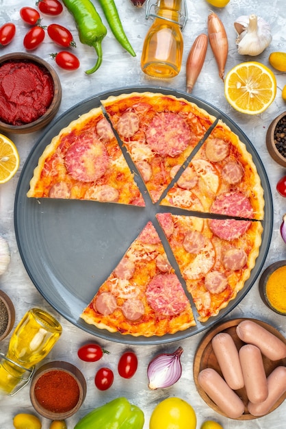 Бесплатное фото Вид сверху вкусной нарезанной пиццы со свежими овощами на белом столе
