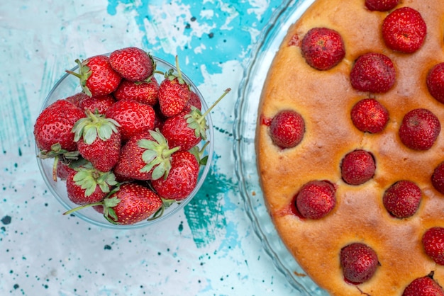 Top view yummy strawberry cake round shaped with fruits and along with fresh red strawberries on the blue desk cake dough sweet biscuit fruit berry