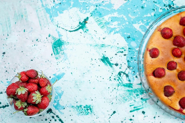 Top view yummy strawberry cake with fruits and along with fresh red strawberries on the bright-blue desk cake dough sweet biscuit fruit berry