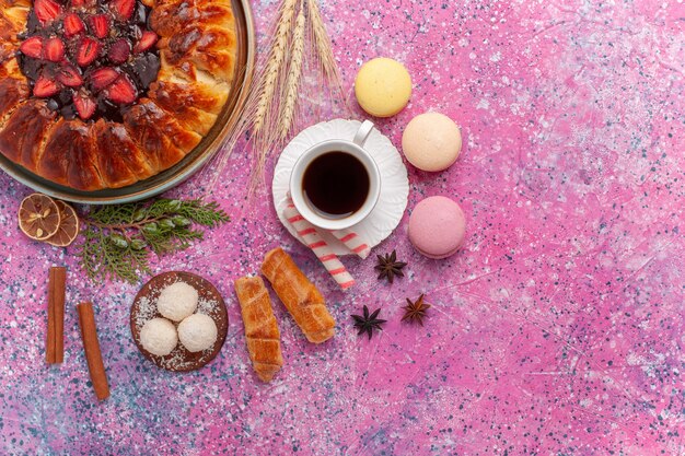 Top view yummy strawberry pie fruity cake with cup of tea on a pink