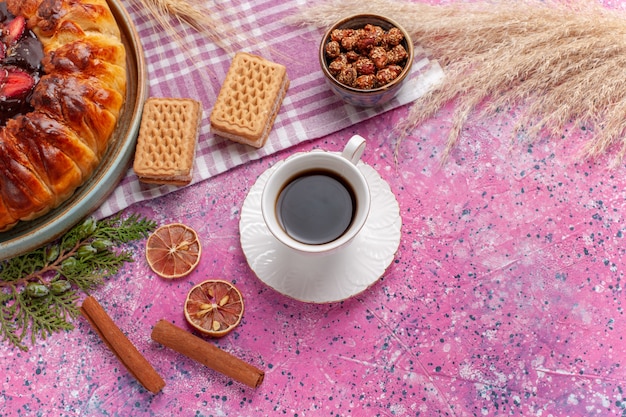 Torta fruttata torta di fragole gustosa vista dall'alto con cialde e tazza di tè sul rosa