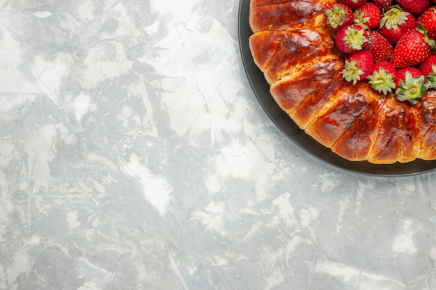 Top view of yummy strawberry pie with fresh red strawberries on light-white desk