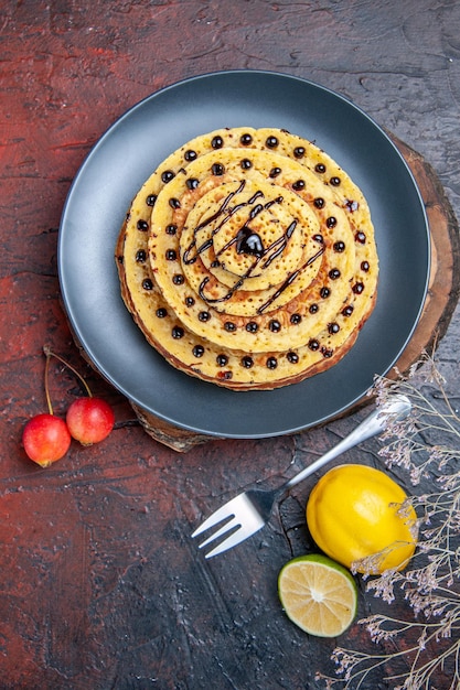 Foto gratuita vista dall'alto gustose frittelle dolci con glassa al cioccolato sulla superficie scura