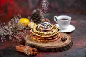 Free photo top view yummy sweet pancakes with tea on dark surface