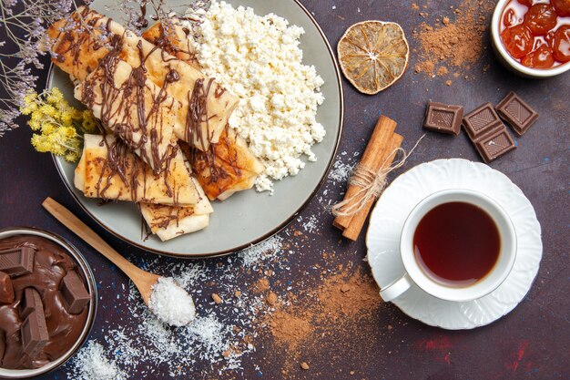 Top view yummy sweet pastries sliced cottage cheese tea on a dark background cookie biscuit sugar sweet cake pastry