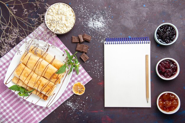 Top view yummy sweet pastries with cottage cheese and jam on dark background cookies biscuit sugar tea sweet cake