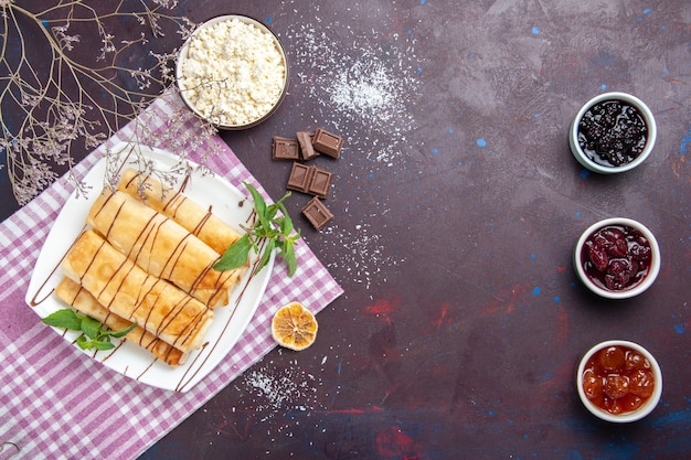 トップビューカッテージチーズとダークデスクのジャムとおいしい甘いペストリークッキービスケットシュガーティースイートケーキ
