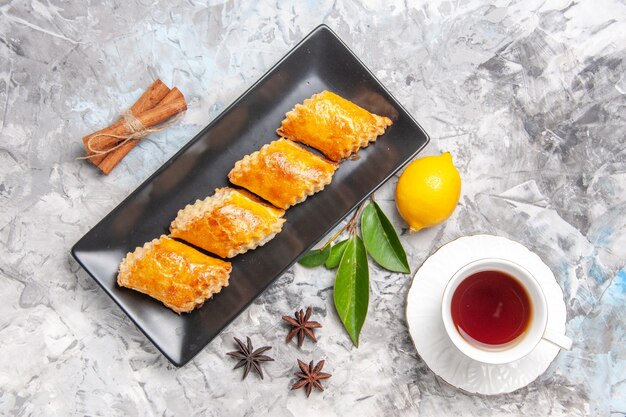 Top view yummy sweet pastries with tea on white sweet pie pastry cake