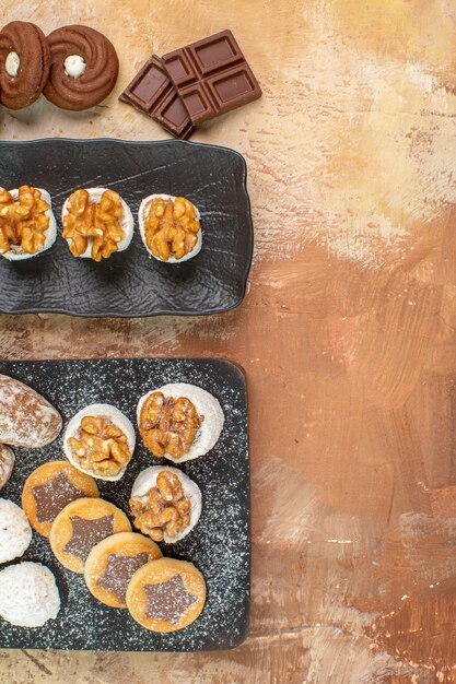 Vista dall'alto squisiti dolci con biscotti e caramelle sulla scrivania in legno