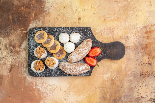 Top view yummy sweets with cookies on wooden desk