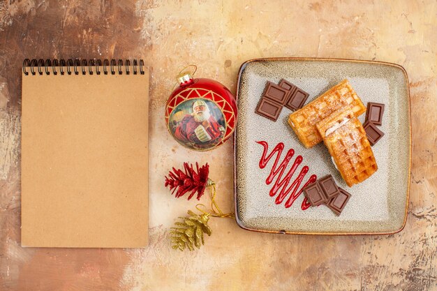 top view yummy waffle cakes with chocolate bars on brown background