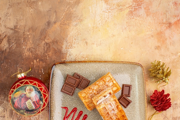 Vista dall'alto gustose torte waffle con barrette di cioccolato sullo sfondo marrone