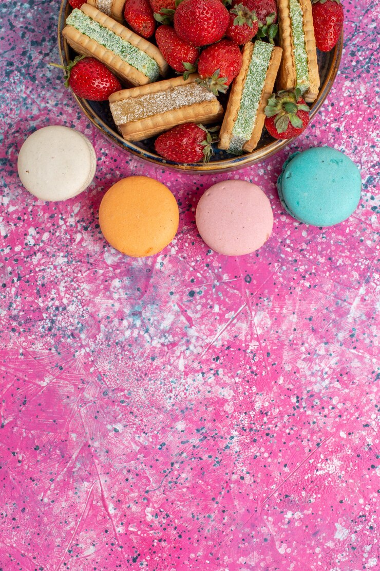 Free Photo top view of yummy waffle cookies with macarons and fresh red strawberries on pink surface