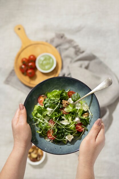 Top viewof person holding a plate of salad and a fork