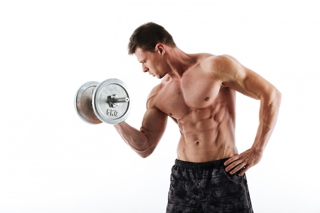 Topless young athletic man working out with heavy dumbbell