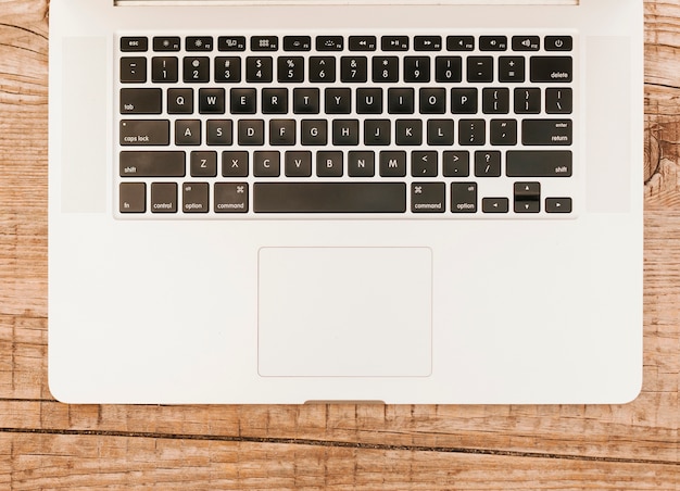 Topviewノートパソコンのキーボードの木製の背景