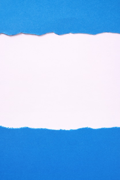 Разорванный голубой бумаги на белом фоне границы кадра вертикали