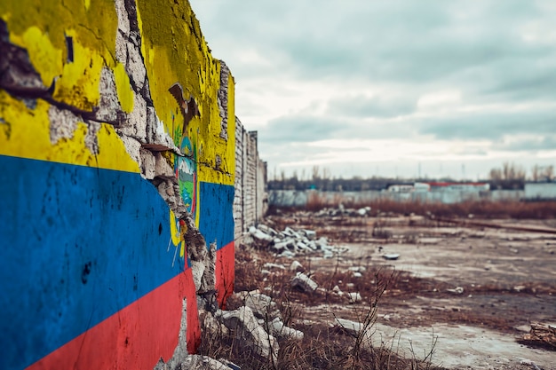 Torn and broken flag of ecuador on cement wall